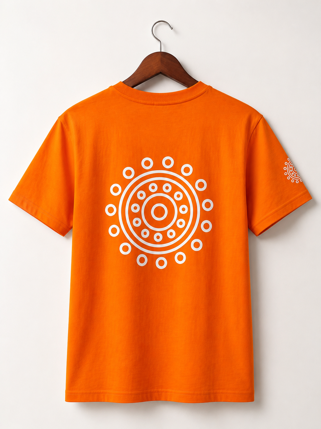 Front view of an oversized orange cotton T-shirt with white mandala graphic on the chest, black mandala print near the hem, and matching sleeve print.