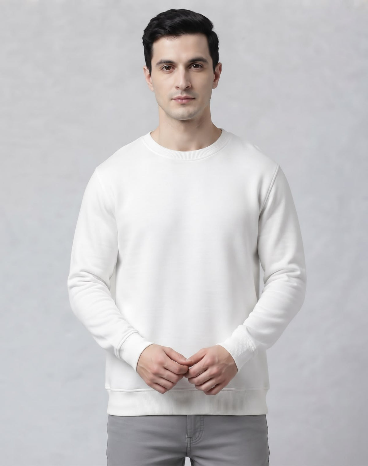 Full body styling of The Sabio solid white crewneck sweatshirt paired with relaxed grey denim and white sneakers.