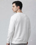 Front full-length view of male model in The Sabio white heavyweight sweatshirt styled with wide-leg grey jeans.