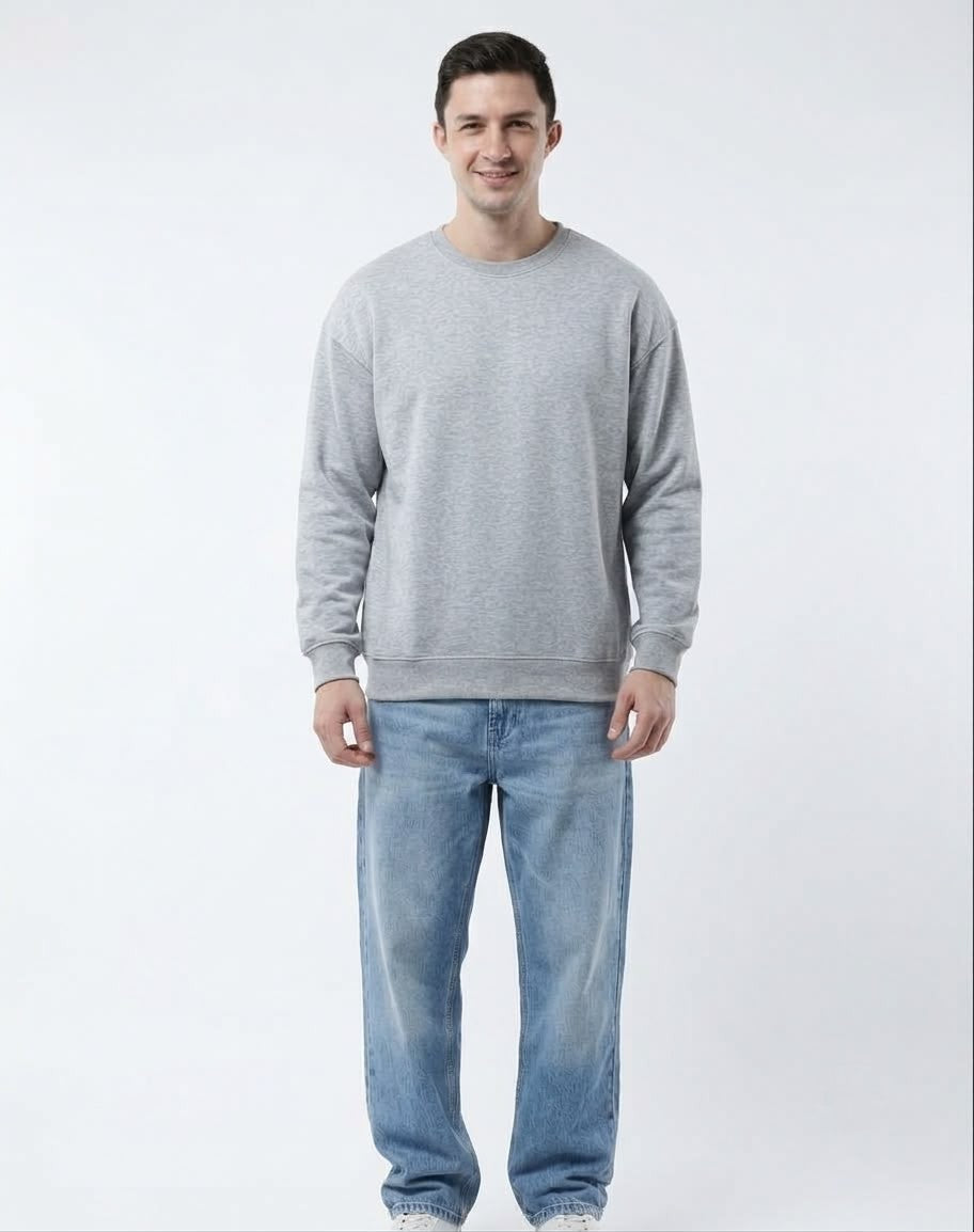Front view of male model wearing The Sabio oversized heather grey fleece sweatshirt paired with light wash denim