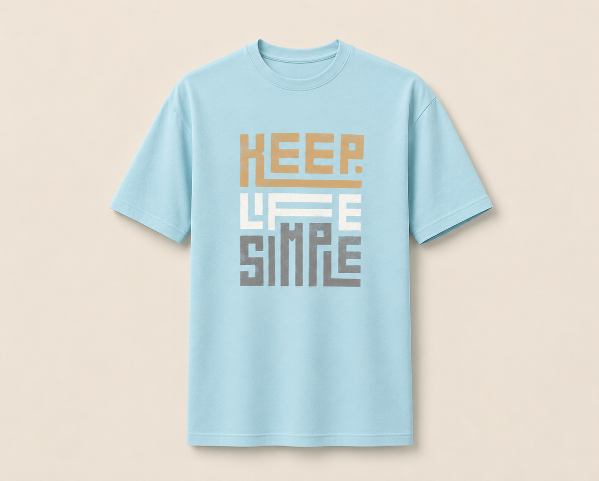 A light blue short-sleeve crewneck t-shirt with a retro-style graphic on the chest reading 'KEEP LIFE SIMPLE' in stacked blocks of tan, white, and gray, displayed against a solid beige background.