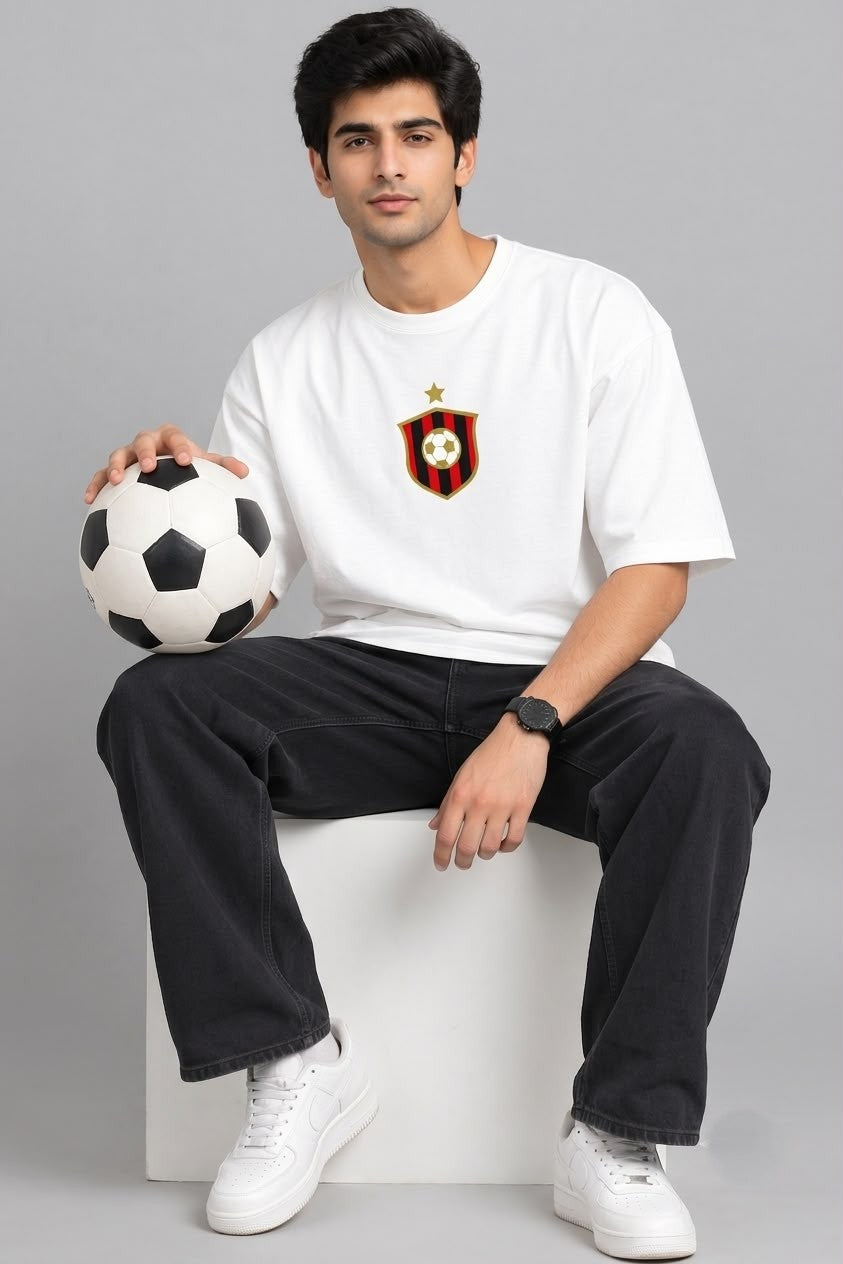 Front product flat view of The Sabio oversized white crew neck cotton t-shirt featuring central striped football crest and gold star.